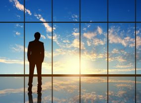 Silhouette of businessman against panoramic office window